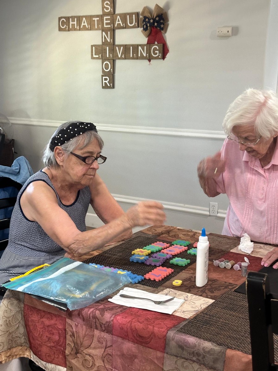Residents making a puzzle-piece craft at The Gardens